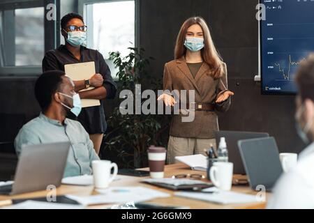 Colleghi che si riunano in sala riunioni, ceo femminile che dà il discorso Foto Stock