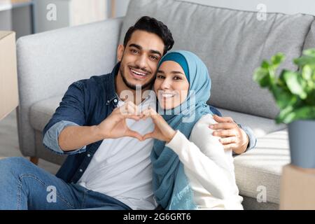 Primo piano della famiglia musulmana che mostra il simbolo del cuore Foto Stock