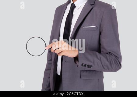 Closeup giovane uomo d'affari asiatico in tuta look lente di ingrandimento per la ricerca isolato su sfondo bianco, espressione uomo d'affari e trovare qualità, inspire Foto Stock