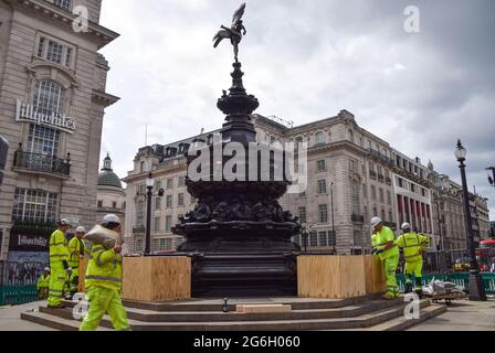 Londra, Regno Unito. 5 luglio 2021. I lavoratori erano impegnati a salire a bordo della Shaftesbury Memorial Fountain, nota anche come Eros, a Piccadilly Circus prima delle semifinali Euro 2020 e finali, per evitare che la folla salisse il monumento. Una grande folla di tifosi ha scalato il punto di riferimento dopo le recenti vittorie dell'Inghilterra nel campionato di calcio. Foto Stock