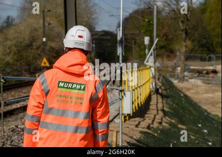 Operaio di pista che sta al lato della pista ferroviaria a Manningtree, Essex, Inghilterra. Foto Stock