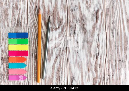 Etichette autoadesive colorate sul righello e matite da primo piano su un tavolo di legno con spazio per la copia Foto Stock