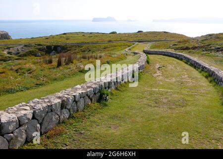 Un basso muro di pietra fiancheggiato tortuoso percorso attraverso la terra pubblica vicino al mare Suances Cantabria Spagna Foto Stock