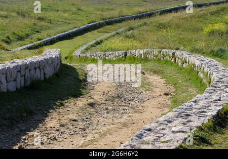 Un basso muro di pietra fiancheggiato tortuoso percorso attraverso la terra pubblica vicino al mare Suances Cantabria Spagna Foto Stock