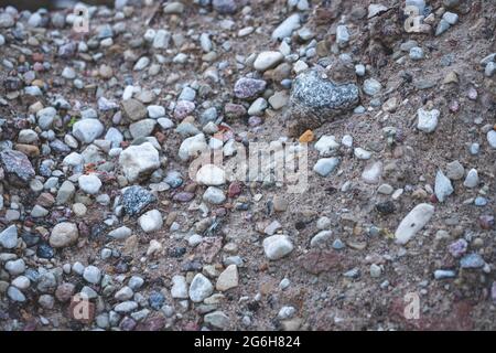 Struttura di fondo per decorare piccoli ciottoli e ghiaia del fondale marino. Mucchio di sabbia e ghiaia con grandi rocce Foto Stock