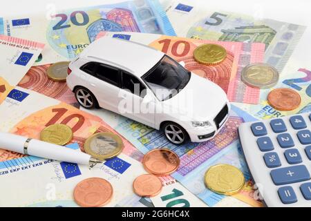 Un'auto euro finanzia ancora vita con una calcolatrice, contanti e un'auto giocattolo. Foto Stock