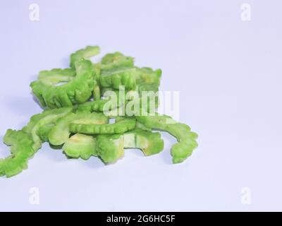 Fresco verde amaro gourd su sfondo bianco. Una delle verdure ha molti benefici anche se ha un sapore amaro. Foto Stock