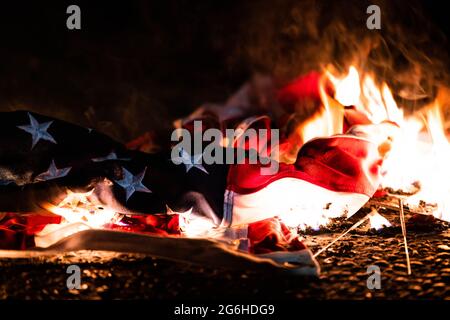 Portland, Stati Uniti. 04 luglio 2020. Una bandiera americana brucia sulla strada di fronte al tribunale Mark O. Hatfield. Portland, Oregon. Il 4 luglio 2020 più di 750 ufficiali del DHS sono stati inviati a Portland nell'estate del 2020 per proteggere la proprietà federale in un piano chiamato 'operazione diligente Valor'. Un rapporto del DHS sostiene che i manifestanti hanno causato danni stimati a 1.6 milioni di dollari al tribunale federale, mentre il costo dell'operazione ha superato i 12 milioni di dollari. (Foto di Mathieu Lewis-Rolland/SIPA USA) Credit: Sipa USA/Alamy Live News Foto Stock