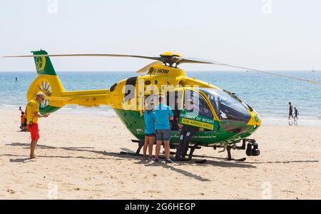 RNLI Lifeguard con Hampshire & Isle of Wight Air Ambulance è atterrato sulla spiaggia di Alum Chine per assistere a un incidente medico a Bournemouth, Dorset UK nel mese di luglio Foto Stock