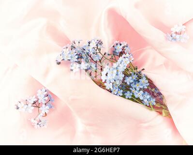 Romantico dimentica-me-non (Myosotis scorpioides) fiori su seta close-up still-life Foto Stock