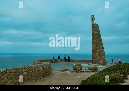 Sintra, Portogallo - 26-06-2021: Vista della gente a Cabo da Roca monumento e colonna in una giornata nuvolosa con vista sull'Oceano Atlantico, il più occidentale Foto Stock