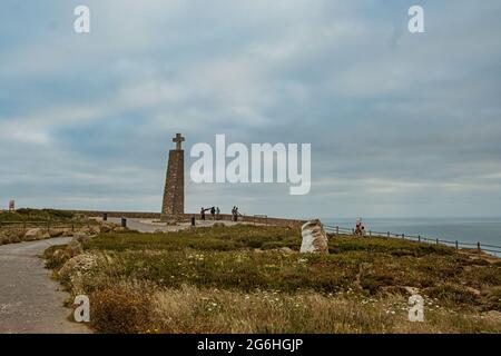 Sintra, Portogallo - 26-06-2021: Vista della gente a Cabo da Roca monumento e colonna in una giornata nuvolosa con vista sull'Oceano Atlantico, il più occidentale Foto Stock