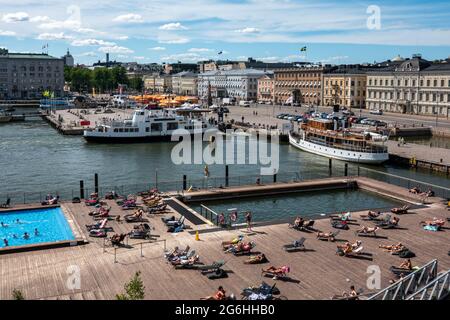 Persone prendere il sole sulla piscina galleggiante Allas Sea Pool ponte a Helsinki, Finlandia Foto Stock