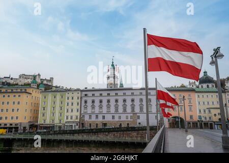 Vista sullo skyline di Salisburgo con bandiere austriache, la Torre dell'orologio del Municipio e la Fortezza di Hohensalzburg sullo sfondo - Salisburgo, Austria Foto Stock