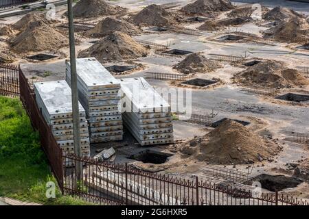 file di box in un cantiere. preparazione del sito per l'installazione di piles. un mucchio di sabbia Foto Stock