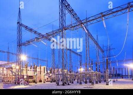 Sottostazione elettrica illuminata al tramonto. Foto Stock