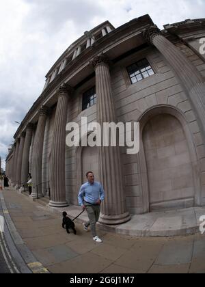 L'uomo cammina cane oltre la Bank of England Threadneedle Street Londra Foto Stock