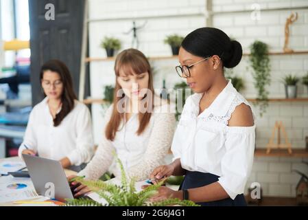 Gruppo di diverse donne imprenditoriali che lavorano insieme in ufficio. Ufficio solo per donne. Foto Stock