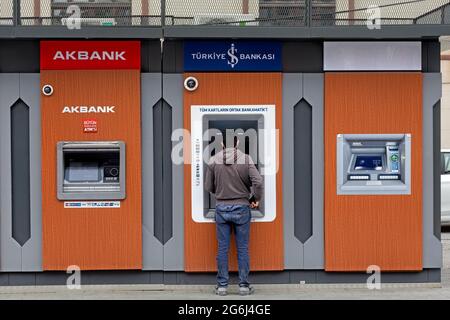 Uomo con abito casual di fronte a Akbank, Bancomat, prelievo di denaro. Karakoy, Istanbul - Turchia. Foto Stock