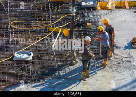 Wien, Vienna: Lavori di calcestruzzo in cantiere, lavoro, installazione di calcestruzzo preconfezionato con una pompa per calcestruzzo nel 22. Donaustadt, Wien, Austriaci Foto Stock