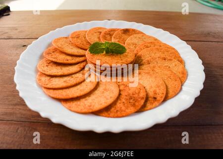 Snack indiano biscotti di patate, spuntini a base di tè serviti a tavola. Mangiare croccante e croccante Foto Stock