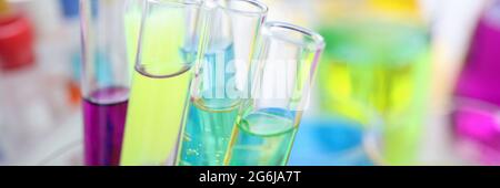 Provette per analisi chimiche con liquido multicolore su scrivania in laboratorio Foto Stock