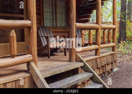 Vista del portico anteriore della rustica capanna di tronchi nel bosco Foto Stock