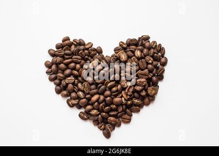 chicchi di caffè aromatici a forma di cuore su sfondo bianco Foto Stock