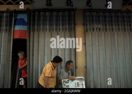 Giornale di lettura per anziani al mercato domenicale di Gaya, Gaya Street, Kota Kinabalu, Sabah, Malesia. Foto Stock