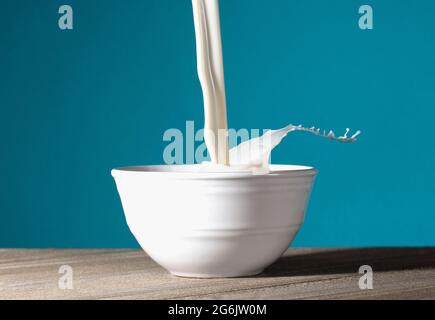 Una ciotola di latte che viene versato e spruzzato fuori Foto Stock