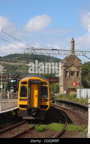 Northern express sprinter dmu passando segnale piuma lasciando Carnforth stazione il 5 luglio 2021. Erbacce in pista e su parte disutilizzata della piattaforma 1. Foto Stock