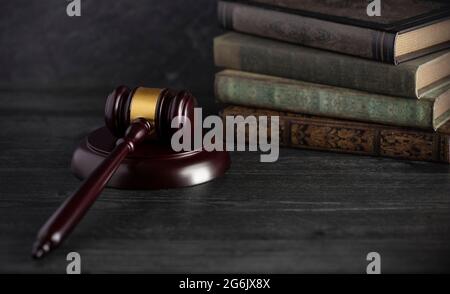 Giudici di legno Gavel su una scrivania con libri in background Foto Stock
