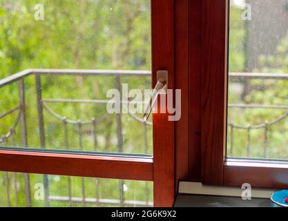 una porta trasparente del balcone con macchie di acqua e polvere sul vetro Foto Stock
