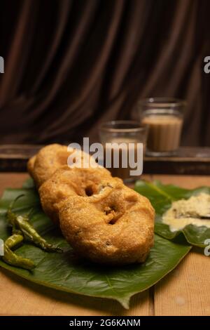 Spuntino Indiano, Medu vada una fritter dell'India del Sud fatta da Vigna mungo e te o Chai Foto Stock