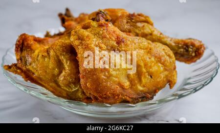 Ayam goreng kunyit o pollo fritto curcuma, pollo fritto e stagionato con curcuma e sale. Foto Stock