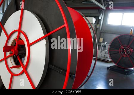 Chevron azienda tubi in plastica moderno impianto di produzione. Primo piano foto della bobina rossa in magazzino. Foto Stock