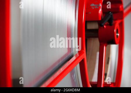 Primo piano foto di plastica bianca o nastro metallico sulla bobina rossa. Foto Stock