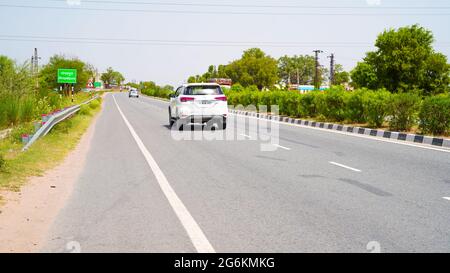 07 luglio 2021 - Reengus, Sikar, India. Concetto di trasporto e viaggi. Auto bianca che passa attraverso la strada a velocità elevata. Foto Stock