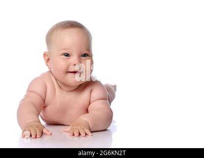 Felice bambino bambino bambino ragazza capretto in pannolino che giace sulla sua pancia, stomaco, strisciando, toccando il pavimento allo spazio di copia Foto Stock