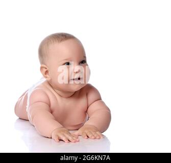 Felice bambino bambino capretto della ragazza del bambino in pannolino sta mentendo sul suo pancy, sullo stomaco, strisciando, ridendo e ridendo Foto Stock