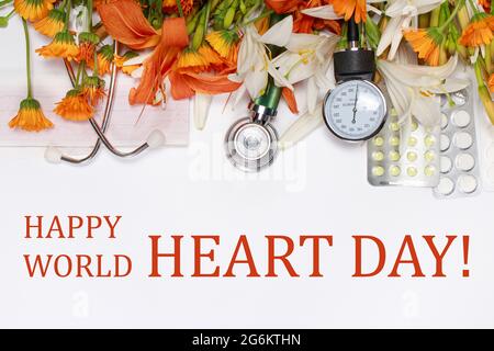 Un biglietto d'auguri con testo Happy World Heart Day - Tablet, sfingomanometro e fonendoscopio con fiori su bianco. Foto Stock