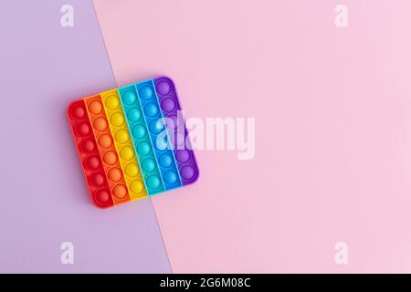 Giocattoli sensoriali colorati anti-stress pop IT per bambini su sfondo multicolore. Foto Stock