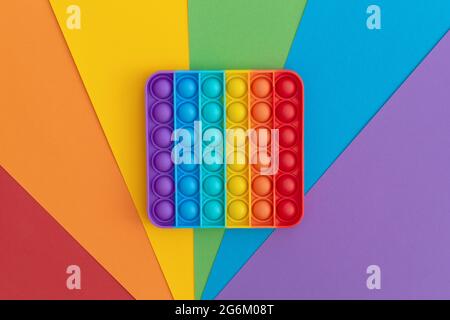 Giocattoli sensoriali colorati anti-stress pop IT per bambini su sfondo multicolore. Foto Stock