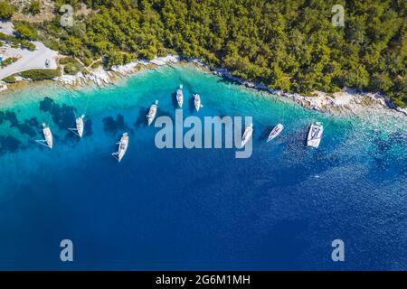 Barche a vela all'ancora nella baia blu di Fiskardo, isola di Cefalonia, Ionio, Grecia. Foto del drone aereo Foto Stock