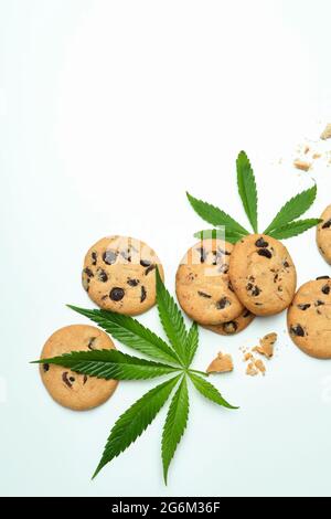 Foglie di cannabis e biscotti su sfondo bianco Foto Stock