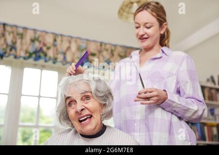 Femmina Parrucchiere Mobile Senior di taglio di capelli Womans a casa Foto Stock