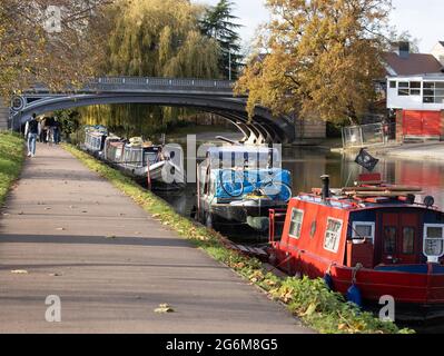 Bella scena del River Cam a Cambridge con barche colorate ormeggiate lungo la riva del fiume con persone che camminano lungo il percorso lungo il fiume Foto Stock