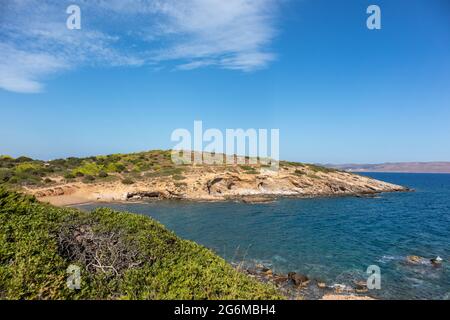 Roccioso, con cespugli verdi, scogliere selvagge, mare linea di mare paesaggio vicino Atene, Grecia. Vivace e colorata vista estiva con blu mare Mediterraneo chiaro Foto Stock