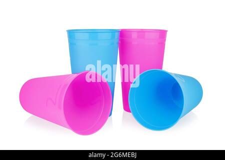 Coppe di plastica vuote rosa blu sfondo bianco isolato primo piano, quattro bicchieri bianchi monouso, bevanda da festa, cocktail, acqua, succo di frutta Foto Stock