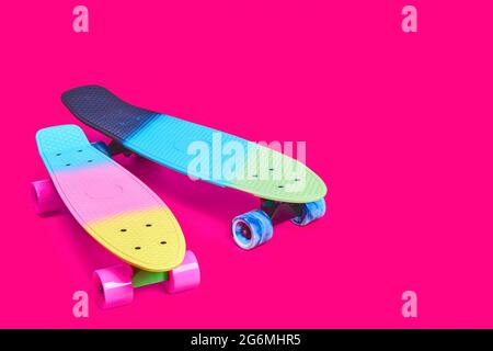 Due skateboard in plastica Rainbow Penny su sfondo cremisi Foto Stock